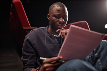 Foto de Retrato del hombre afroamericano leyendo guion en el teatro y ensayando para la actuación - Imagen libre de derechos