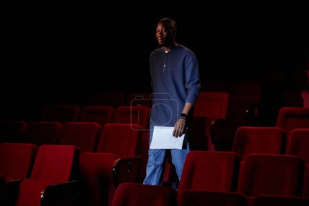 Téléchargez les photos : Portrait d'homme noir marchant vers la scène dans l'espace vide de copie d'audience de théâtre - en image libre de droit