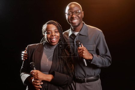 Téléchargez les photos : Portrait de deux artistes afro-américains sur scène regardant la caméra avec projecteur - en image libre de droit