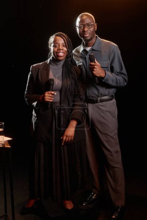 Portrait of two African American couple performing on stage together with spotlight