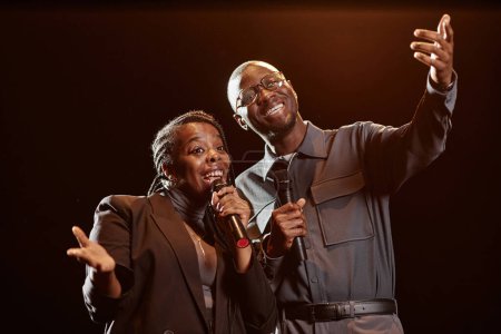 Téléchargez les photos : Portrait taille haute de deux artistes afro-américains sur scène parlant au public sous les projecteurs - en image libre de droit