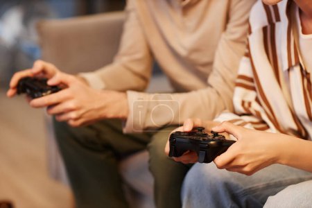 Foto de Primer plano de pareja joven jugando videojuegos en casa y sosteniendo controladores, espacio para copiar - Imagen libre de derechos