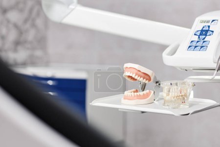 Close up background image of tooth model with tools at dentists chair in dental clinic setting, copy space