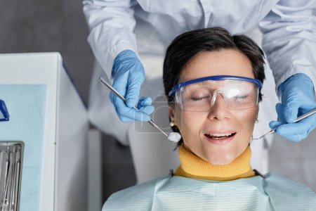 Téléchargez les photos : Vue du dessus de la femme mature allongée sur une chaise dentaire pendant l'examen des dents, espace de copie - en image libre de droit