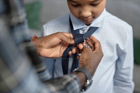 Foto de Acercamiento de amor afro-americano padre atar corbata para hijo primer día de escuela - Imagen libre de derechos