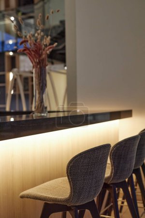 Foto de Imagen de fondo vertical del mostrador de bar en el interior de la cafetería moderna con sillas altas y acentos de iluminación led - Imagen libre de derechos