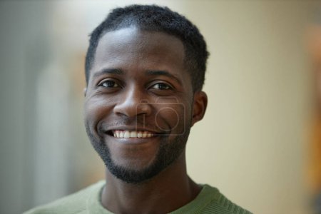 Photo for Closeup portrait of smiling Black man looking at camera with blurred background in green tones copy space - Royalty Free Image