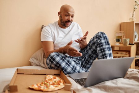Foto de Retrato de hombre negro disfrutando de holgazán fin de semana en casa y hablando a través de chat de vídeo, espacio de copia - Imagen libre de derechos