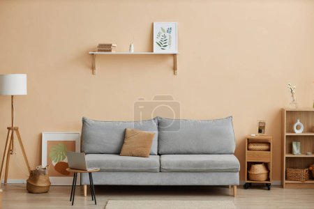 Foto de Interior de la sala de estar mínima con sofá cómodo y muebles de madera simples contra la pared de luz, espacio de copia - Imagen libre de derechos