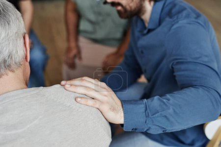 Photo for Closeup of male psychologist comforting senior man in mental health support group - Royalty Free Image