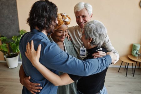 Téléchargez les photos : Groupe de personnes âgées embrassant en cercle tout en célébrant le succès ensemble - en image libre de droit