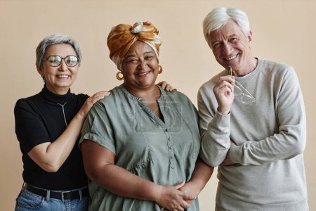 Téléchargez les photos : Groupe diversifié de personnes âgées posant ensemble et souriant à la caméra - en image libre de droit