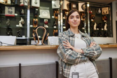 Photo for Waist up portrait of young woman working in music store and looking at camera posing confidently with arms crossed, copy space - Royalty Free Image