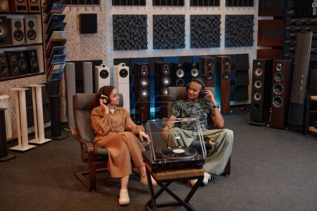Téléchargez les photos : Portrait de jeune couple écoutant des disques vinyles à la maison et appréciant la musique, espace de copie - en image libre de droit