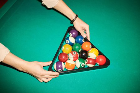 Photo for Closeup of hands setting billiard balls in triangle frame ready for game of pool on green canvas table copy space - Royalty Free Image