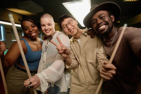 Foto de POV de diversos grupos de amigos tomando fotos selfie en el club de billar y sonriendo a la cámara juntos - Imagen libre de derechos