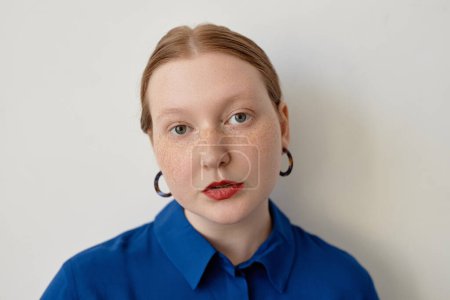 Téléchargez les photos : Portrait minimal de femme aux cheveux rouges créatifs regardant la caméra portant du rouge à lèvres rouge, espace de copie - en image libre de droit