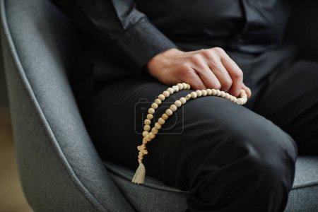 Photo for Closeup of unrecognizable man holding rosary on lap during therapy session, copy space - Royalty Free Image