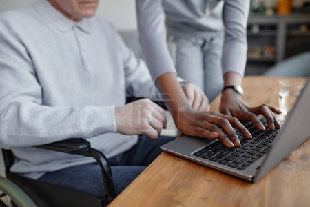 Foto de Primer plano de la mujer negra que ayuda al hombre con discapacidad usando la computadora, espacio para copiar - Imagen libre de derechos