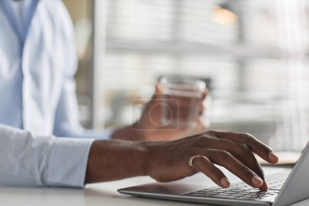 Téléchargez les photos : Gros plan de la main masculine avec bague dorée tapant au clavier de l'ordinateur portable dans le bureau, espace de copie - en image libre de droit