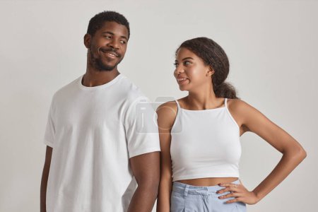Téléchargez les photos : Portrait minimal de jeune couple noir se regardant sur fond blanc - en image libre de droit
