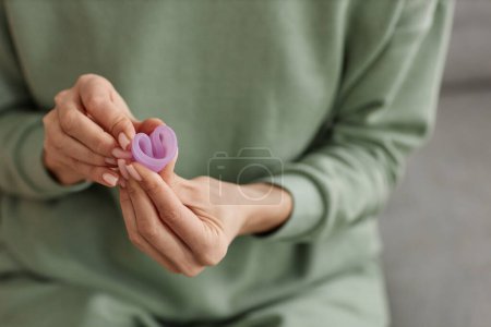 Photo for Close up of unrecognizable woman holding menstrual cup to camera and demonstrating folding technique copy space - Royalty Free Image