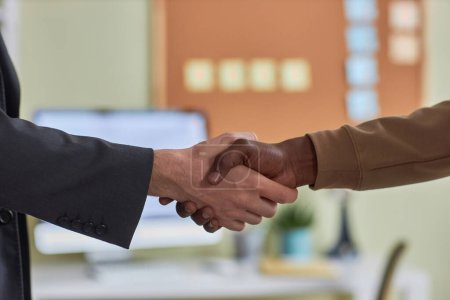 Foto de Vista lateral primer plano de dos personas estrechando la mano en la oficina en la reunión de negocios o gesto de saludo, espacio de copia - Imagen libre de derechos
