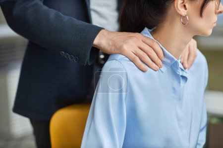 Photo for Closeup of inappropriate contact in office, male boss rubbing shoulders of young assistant, copy space - Royalty Free Image