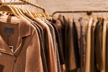 Photo for Warm toned background image of coats on rack in clothing store, copy space - Royalty Free Image