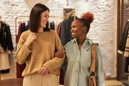 Téléchargez les photos : Portrait taille haute de deux jeunes femmes faisant du shopping ensemble et marchant vers la caméra se souriant - en image libre de droit