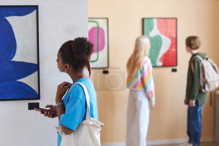 Photo for Colorful shot of diverse group of teenagers looking at art in modern art gallery or museum, copy space - Royalty Free Image