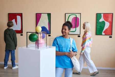 Foto de Retrato colorido del grupo de adolescentes mirando arte abstracto en el museo, espacio de copia - Imagen libre de derechos
