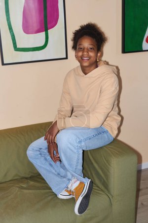 Téléchargez les photos : Portrait de mode d'une adolescente afro-américaine portant un jean et un sweat à capuche, tourné avec flash - en image libre de droit