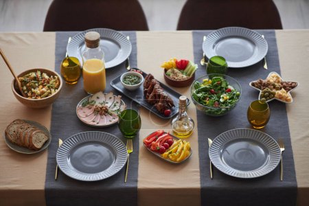 Hochwinkelhintergrundbild von Lebensmitteln auf kleinem Esstisch für vier Personen mit blauem Dekor Kopierraum