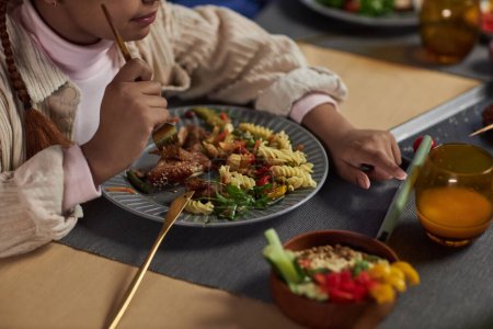 Nahaufnahme eines jungen Mädchens mit Smartphone beim Essen am Esstisch und beim Anzapfen von Bildschirmkopierfläche