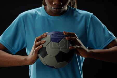 Photo for Cropped concept shot of female football player holding ball to chest and looking down copy space - Royalty Free Image