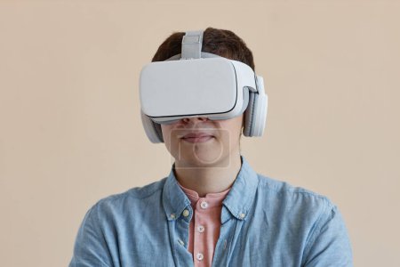 Téléchargez les photos : Portrait de jeune homme en lunettes VR sans fil isolé sur fond beige - en image libre de droit
