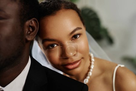 Foto de Primer plano retrato de la hermosa mujer negra como novia mirando a la cámara sobre los maridos hombro - Imagen libre de derechos