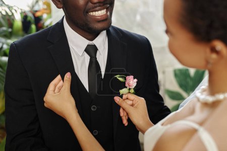 Photo for Closeup of black young couple getting married with bride adjusting jacket and boutonniere, copy space - Royalty Free Image