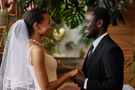 Photo for Waist up portrait of young black couple getting married and looking at each other holding hands - Royalty Free Image