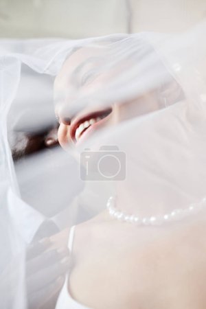 Photo for Closeup detail shot of young bride smiling peeking from veil, copy space - Royalty Free Image