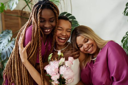 Foto de Candid cintura hacia arriba retrato de la mujer negra feliz como novia joven abrazando damas de honor durante la ceremonia de boda - Imagen libre de derechos