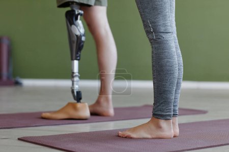 Téléchargez les photos : Gros plan de la personne avec la jambe prothétique en classe de yoga à l'intérieur contre le mur vert, espace de copie - en image libre de droit