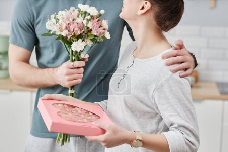 Foto de Primer plano del joven romántico dando flores a la esposa sorprendente en el día de San Valentín o aniversario - Imagen libre de derechos