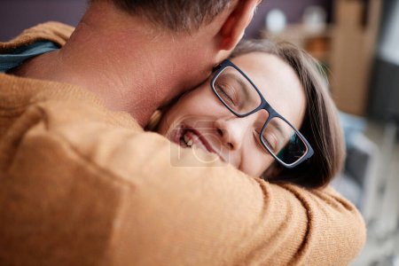 Téléchargez les photos : Gros plan candide de l'adolescente avec paralysie cérébrale embrassant père et souriant joyeusement - en image libre de droit