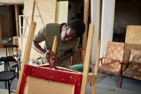 Téléchargez les photos : Portrait taille haute de jeune homme noir réparant de vieux meubles dans un atelier de menuiserie, espace de copie - en image libre de droit