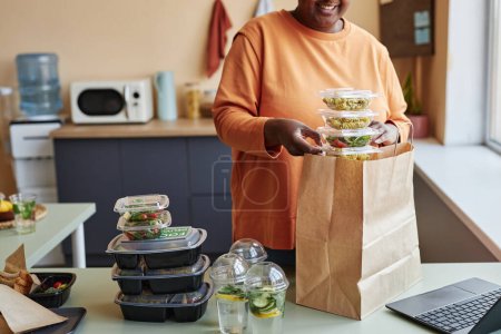 Téléchargez les photos : Plan recadré de femme noire déballage ordre de livraison de nourriture à la maison, espace de copie - en image libre de droit
