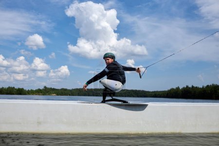 Foto de Retrato de acción del joven haciendo deportes extremos al aire libre y saltando en rampa en el agua - Imagen libre de derechos