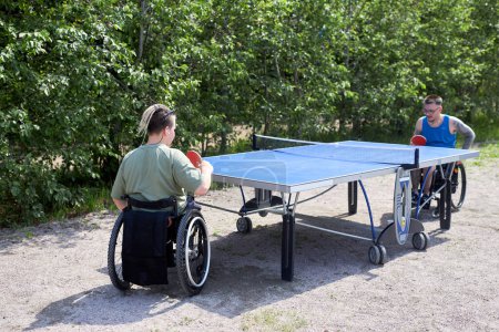 Photo for Portrait of two young people with disabilty playing table tenning outdoors, copy space - Royalty Free Image