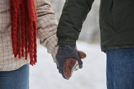 Téléchargez les photos : Gros plan de jeune couple tenant la main en hiver portant de jolies mitaines en tricot, espace de copie - en image libre de droit